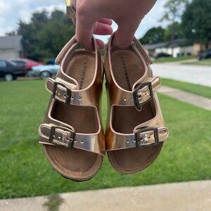 Lucky Brand Gold Sandals with Wide Strap and Metal Buckle.